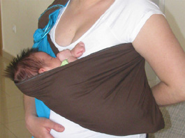 Νεογέννητο σε cradle θέση μέσα σε sling