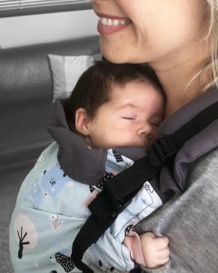 Newborn sleeping peacefully in ergonomic baby carrier from Asteraki Slings